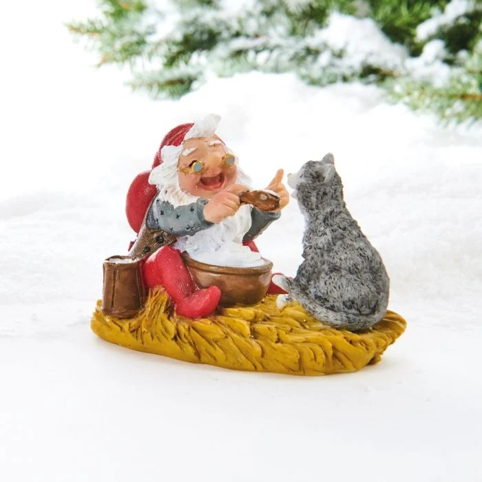 Jultomte äter risgrynsgröt med katten